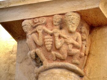 Combronde, église Saint-Genès, chapiteau 5, homme portant des grappes et singe cordé